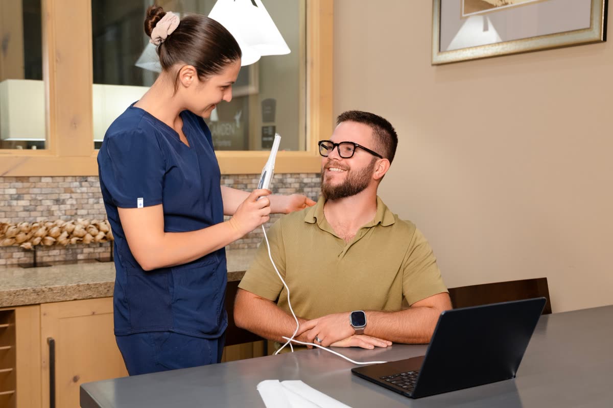A staff member helps a patient with the SmileSafe intraoral camera
