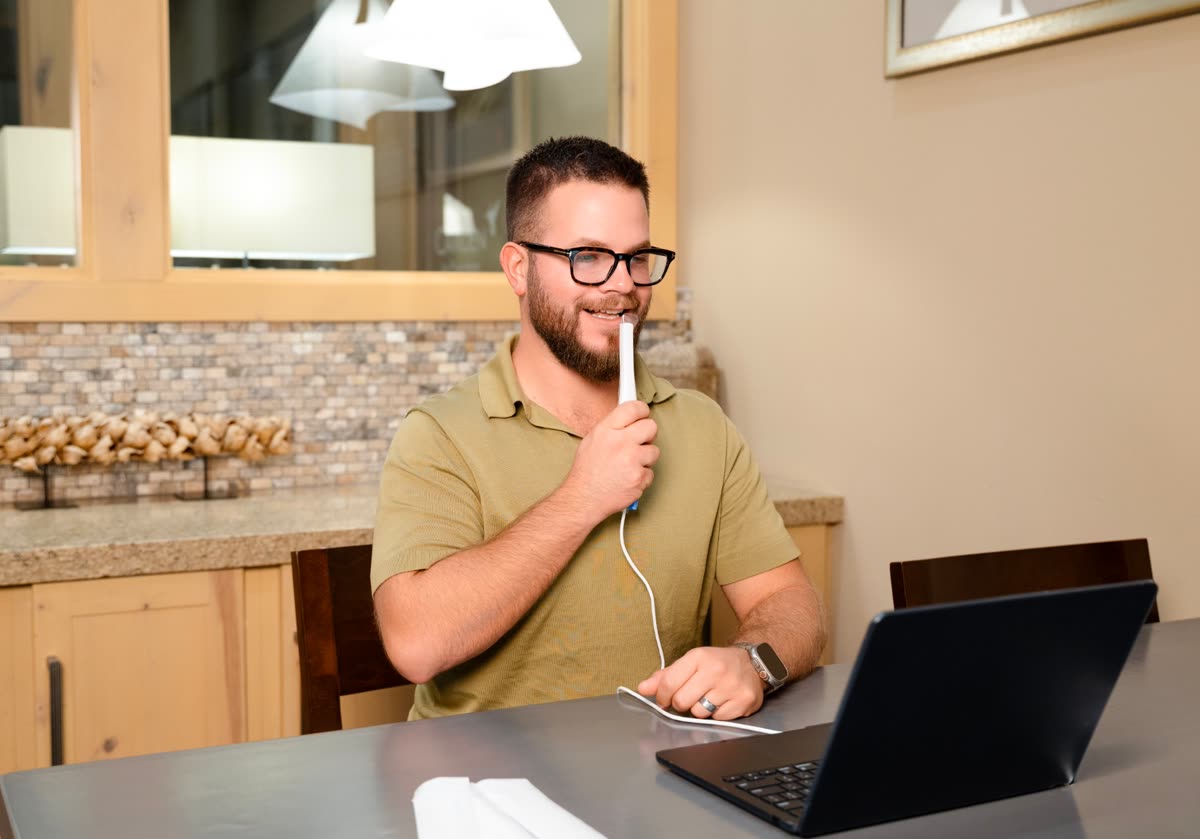 A patient scanning his own teeth with the SmileSafe intraoral camera
